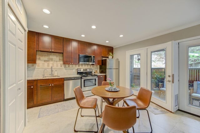 kitchen featuring sink, crown molding, backsplash, stainless steel appliances, and light stone counters