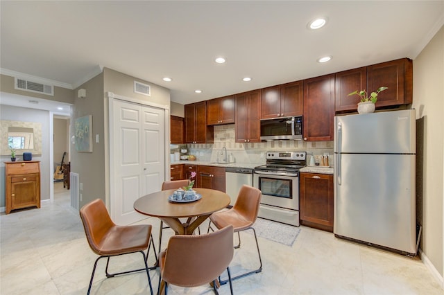 kitchen with backsplash, ornamental molding, sink, and appliances with stainless steel finishes