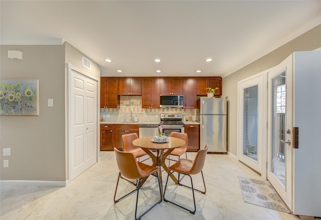 dining room featuring sink, ornamental molding, and french doors