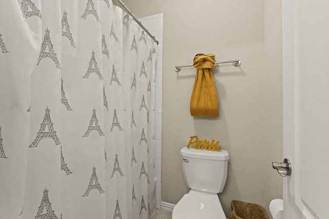 bathroom with toilet and a shower with shower curtain