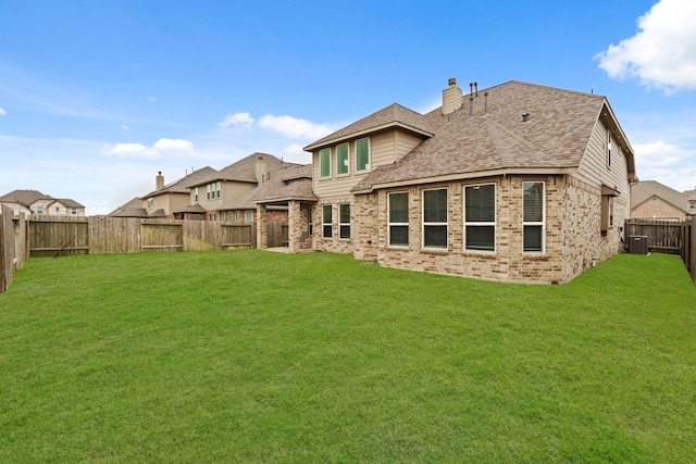 rear view of property with central AC and a lawn