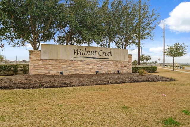 community / neighborhood sign featuring a yard