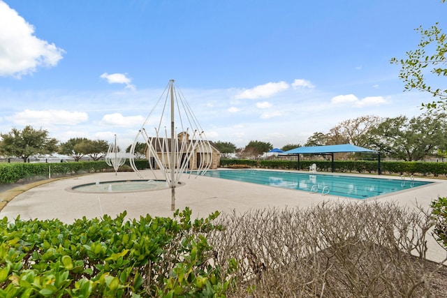 view of swimming pool featuring a hot tub and a patio area