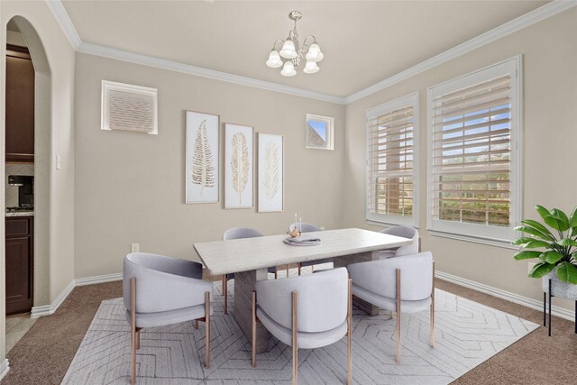 dining space featuring an inviting chandelier, crown molding, and light carpet