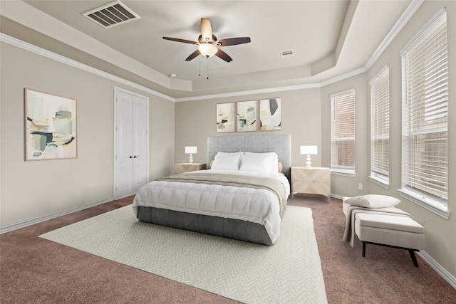 carpeted bedroom featuring a raised ceiling, crown molding, and multiple windows