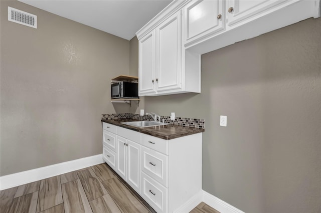 kitchen featuring white cabinetry and sink