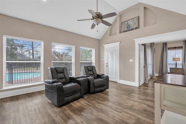 living room with hardwood / wood-style flooring, ceiling fan, and high vaulted ceiling