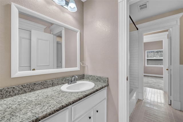 bathroom with tile patterned flooring, bathing tub / shower combination, and vanity