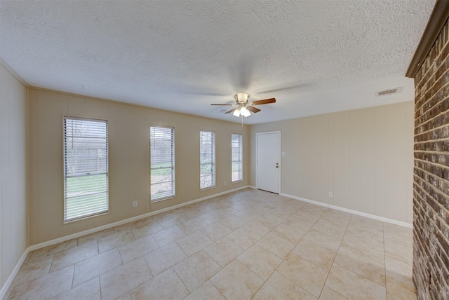 tiled spare room with ceiling fan and a textured ceiling