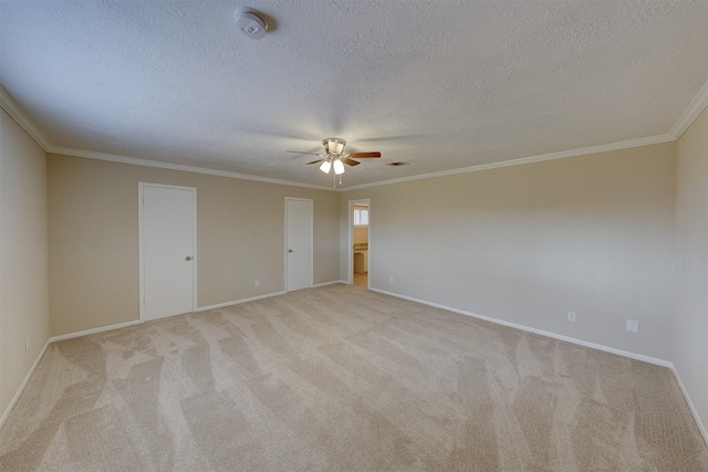 carpeted empty room featuring ceiling fan, ornamental molding, and a textured ceiling