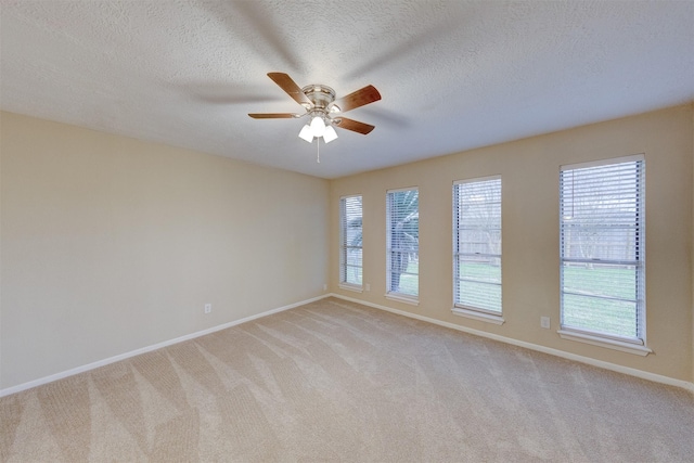 spare room featuring light colored carpet, a textured ceiling, and ceiling fan