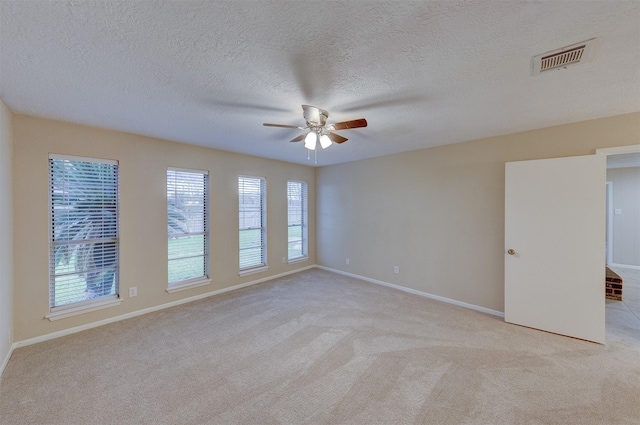 unfurnished room with light carpet, a textured ceiling, and ceiling fan