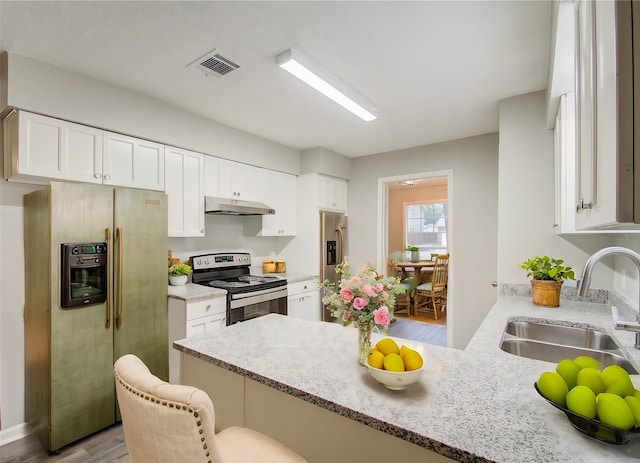 kitchen with appliances with stainless steel finishes, sink, a kitchen breakfast bar, and kitchen peninsula