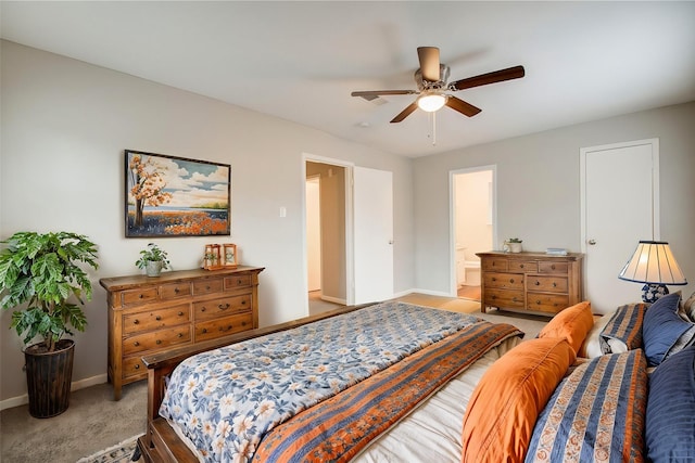 carpeted bedroom with ensuite bath and ceiling fan