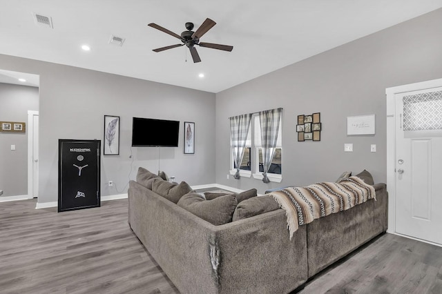 living room featuring wood-type flooring and ceiling fan