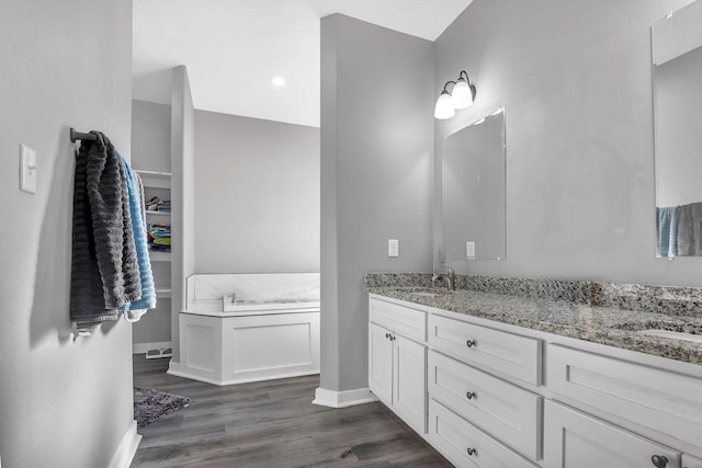 bathroom featuring vanity, a bathtub, and hardwood / wood-style flooring