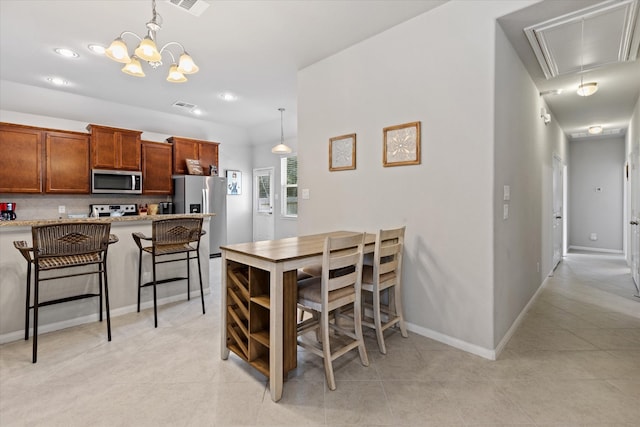 kitchen with light stone counters, decorative light fixtures, a breakfast bar, and appliances with stainless steel finishes