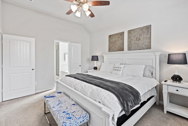 bedroom featuring ceiling fan, light colored carpet, vaulted ceiling, and ensuite bath