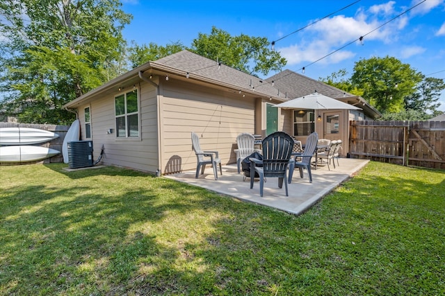 rear view of property featuring central AC unit, a yard, and a patio