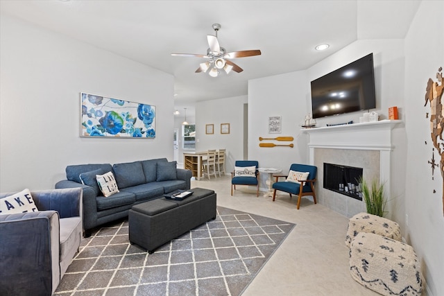 living room featuring a tiled fireplace, tile patterned flooring, and ceiling fan