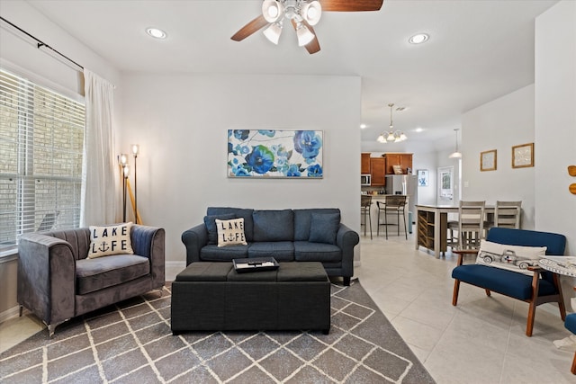 living room with ceiling fan with notable chandelier and tile patterned floors