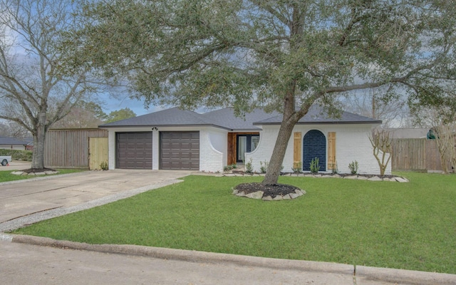 ranch-style home featuring a garage and a front lawn