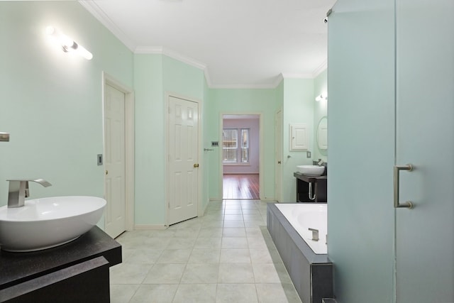 bathroom with crown molding, tile patterned floors, vanity, and tiled tub