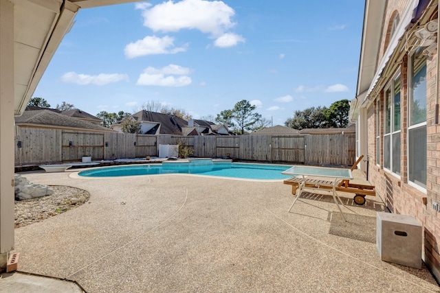 view of pool with a diving board and a patio area