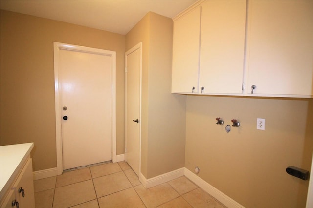 washroom with cabinets, washer hookup, and light tile patterned floors