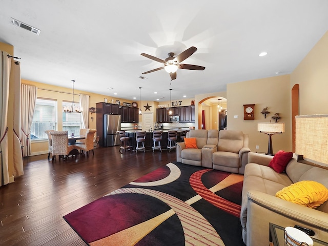 living room featuring dark hardwood / wood-style floors and ceiling fan with notable chandelier