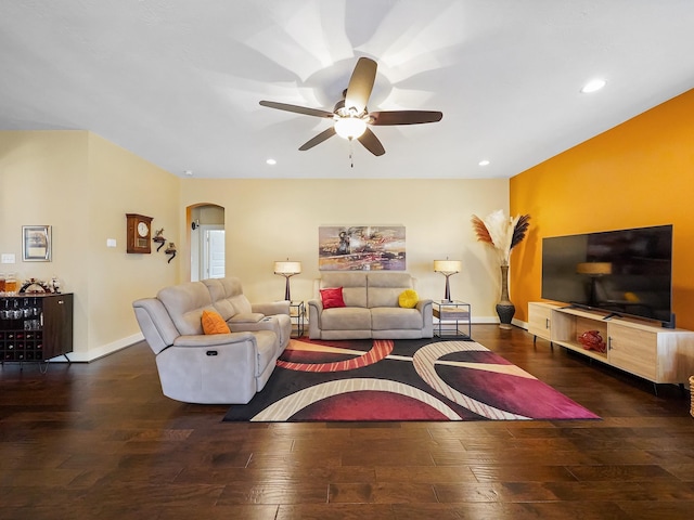 living room with dark wood-type flooring and ceiling fan