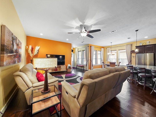 living room featuring dark hardwood / wood-style floors and ceiling fan with notable chandelier