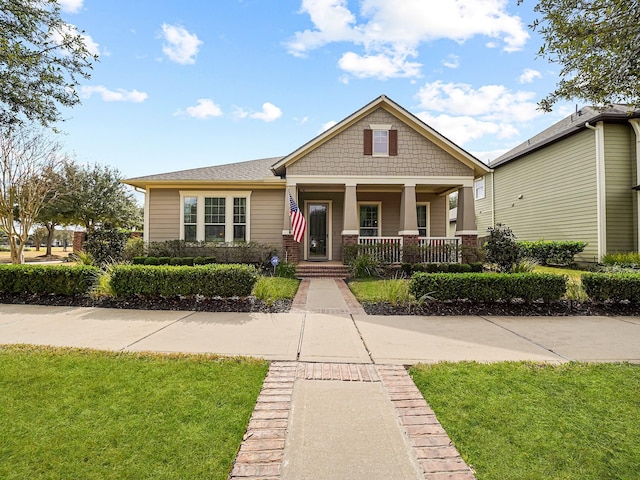 craftsman house with a porch and a front yard