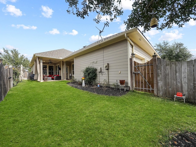 back of house featuring outdoor lounge area, ceiling fan, and a lawn