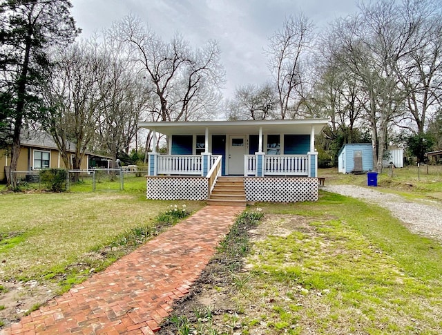 view of front of house featuring a porch, a storage unit, and a front lawn