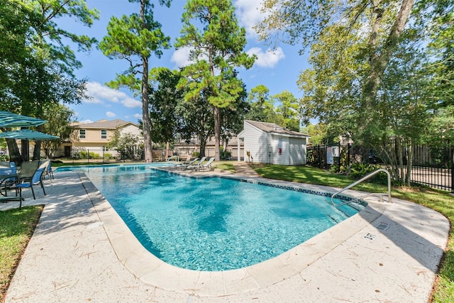 view of pool featuring an outbuilding and a patio area