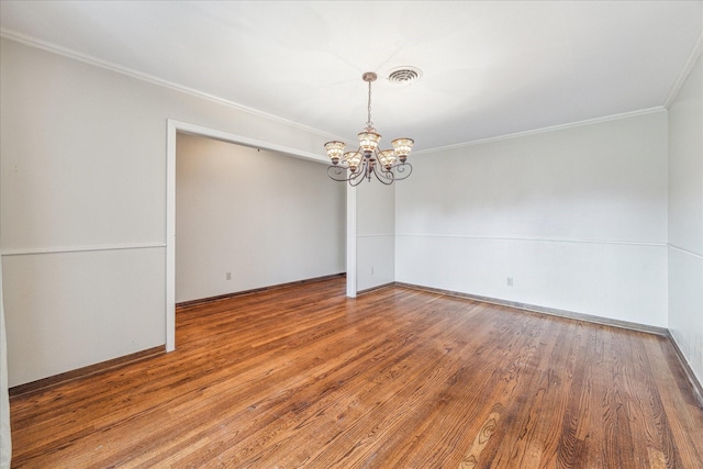 spare room with ornamental molding, hardwood / wood-style floors, and an inviting chandelier