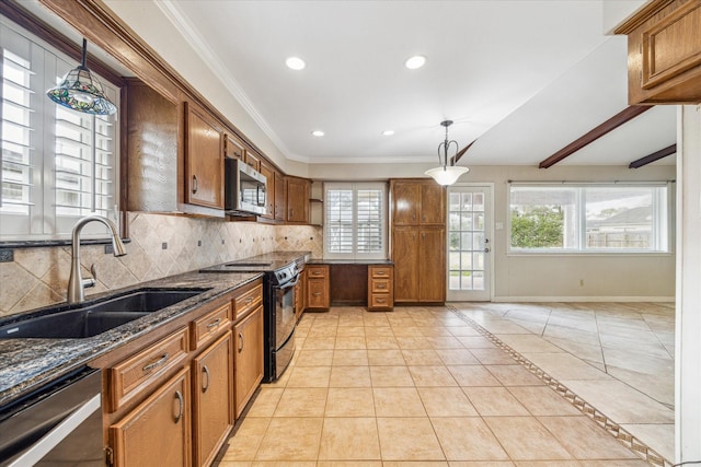 kitchen featuring sink, decorative light fixtures, dark stone countertops, appliances with stainless steel finishes, and backsplash