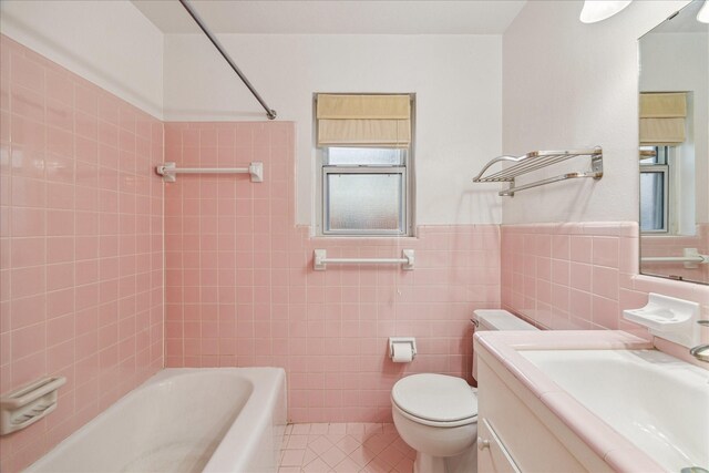 full bathroom with tile patterned flooring, tile walls, vanity, shower / bathing tub combination, and toilet