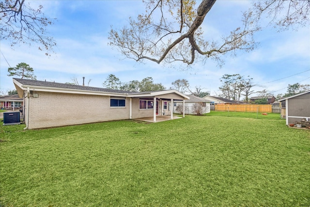 rear view of property with a patio, a lawn, and central air condition unit