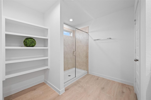 bathroom with hardwood / wood-style floors and an enclosed shower