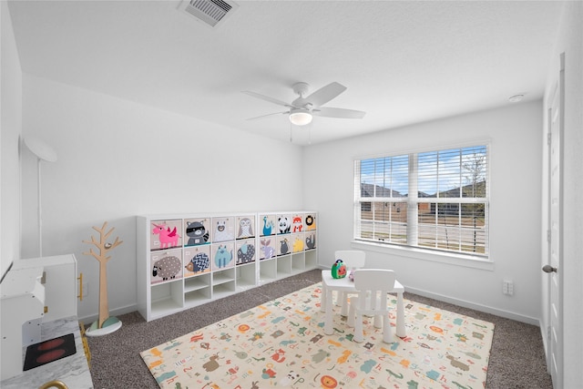 recreation room featuring ceiling fan and dark colored carpet