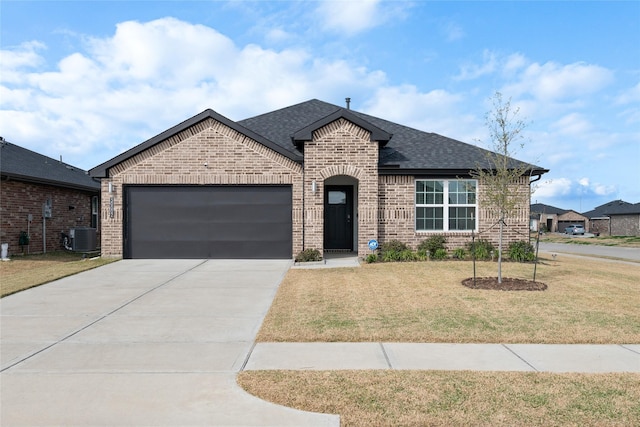 view of front of house with a garage, a front yard, and central AC unit