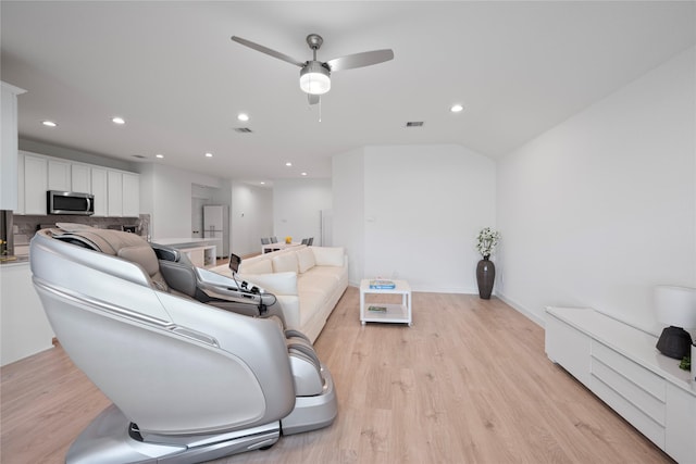 living room with vaulted ceiling, ceiling fan, and light hardwood / wood-style floors