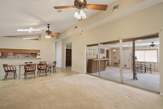 unfurnished living room featuring light carpet, high vaulted ceiling, and ceiling fan