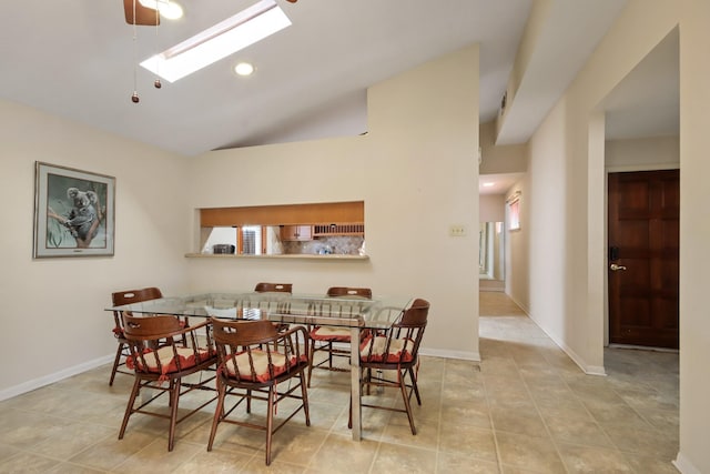 dining space with lofted ceiling with skylight and light tile patterned flooring