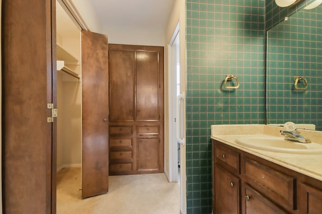 bathroom with vanity and tile walls