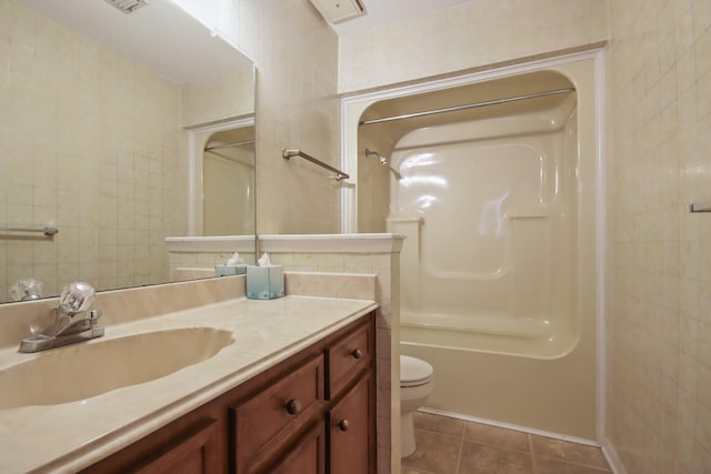 full bathroom with toilet, tub / shower combination, tile walls, vanity, and tile patterned flooring