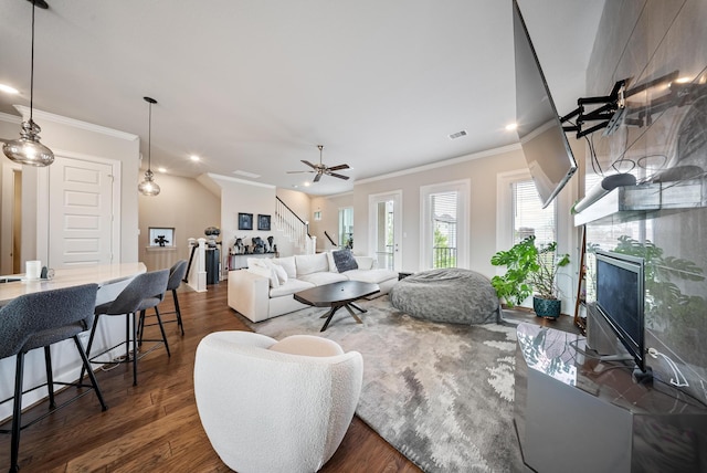 living room featuring crown molding, ceiling fan, a fireplace, and dark hardwood / wood-style flooring