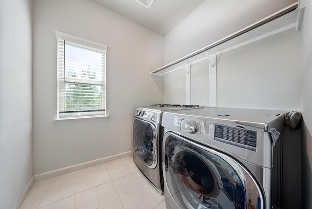 washroom with washer and dryer and light tile patterned floors